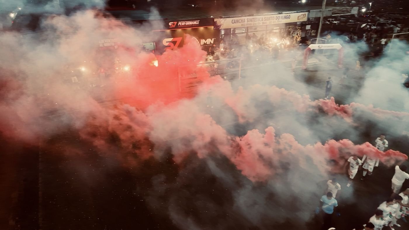 Vista aérea de la cancha cubierta de humo rojo