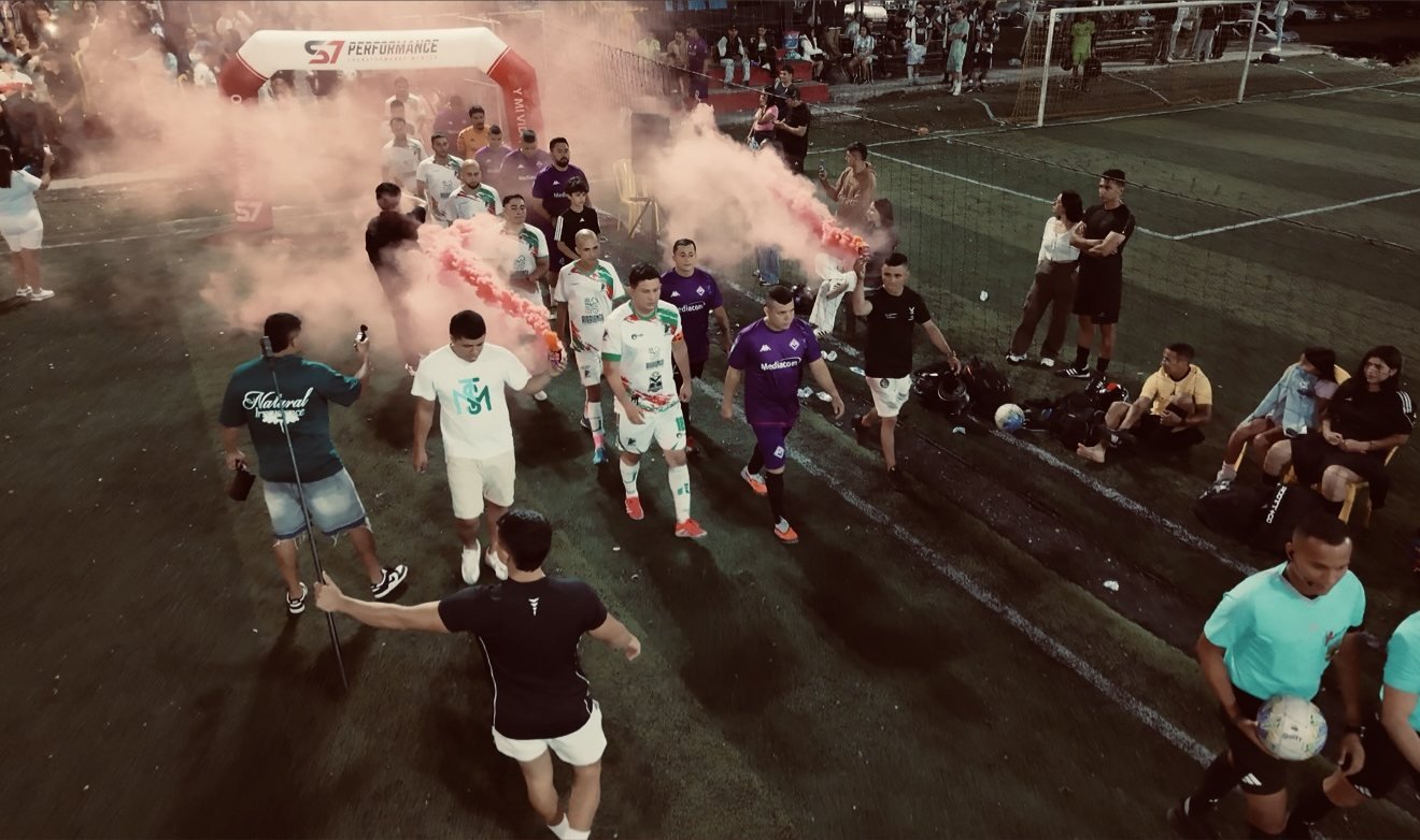 Finalistas saliendo a la cancha por el arco S7 entre bengalas y humo